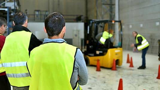 A photo of a forklift training class in a warehouse